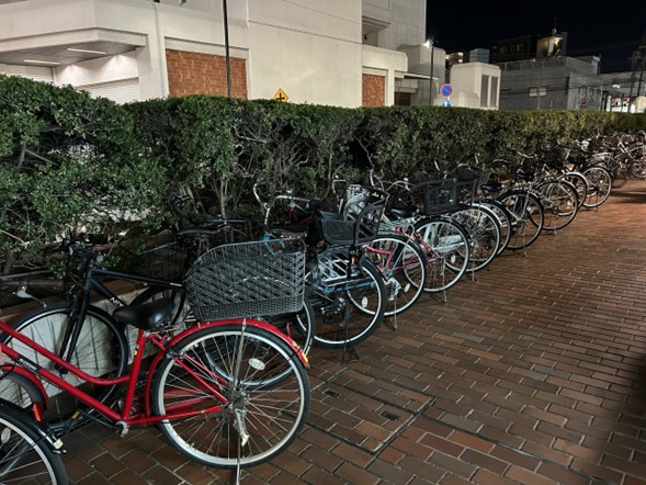 A row of bikes lined up on the sidewalk. 