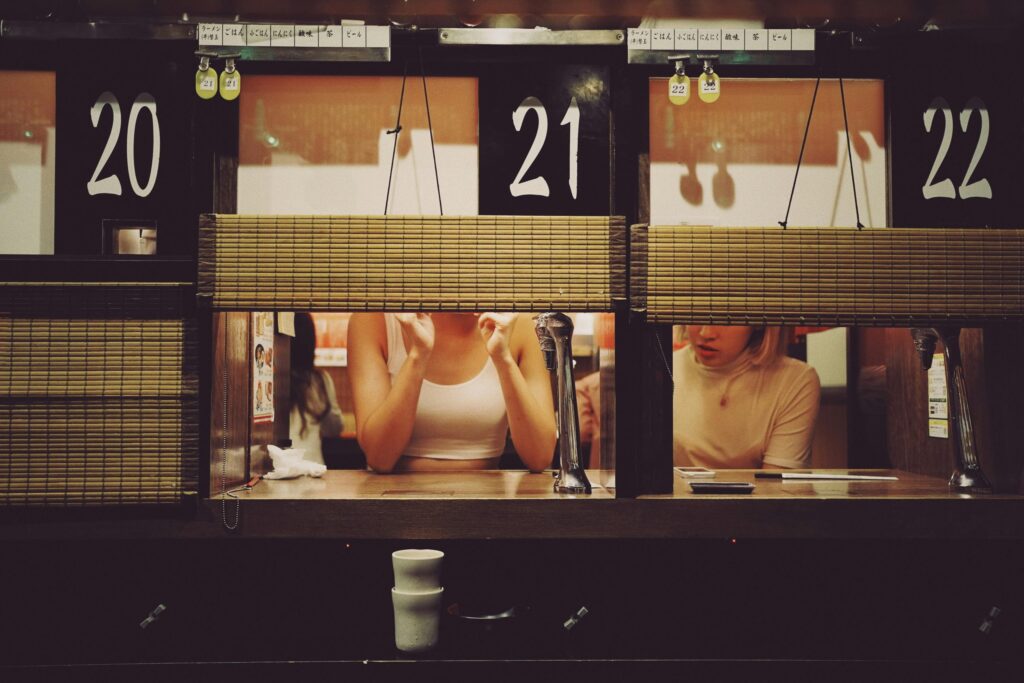 Two individuals enjoying ramen together at a famous ramen chain.  