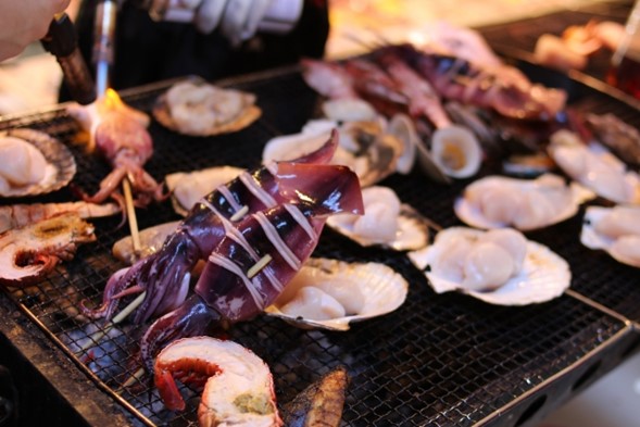 Ikayaki and various seafoods on a grill