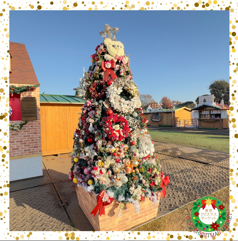 Beautifully decorated Christmas tree at the Tokyo Christmas Market, adorned with colorful ornaments, ribbons, and wreaths under a clear blue sky.