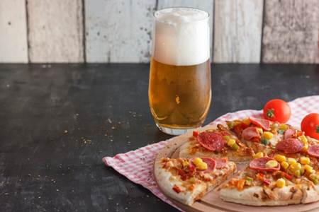 Corn pizza with a glass of beer