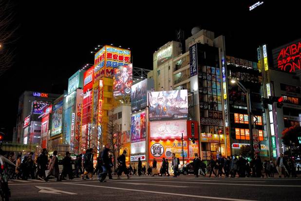 A busy street lit by neon lights in Akihabara